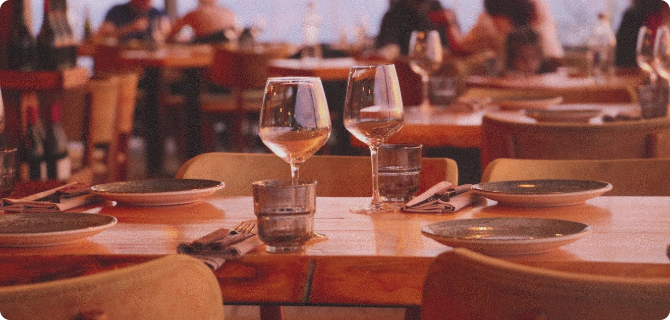 Warm beleuchtete, eingedeckte Restauranttische